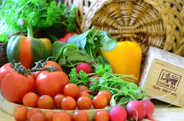 Tomates, rabanetes, pimentos, salsa e wickerwork handbasket — Fotografia de Stock