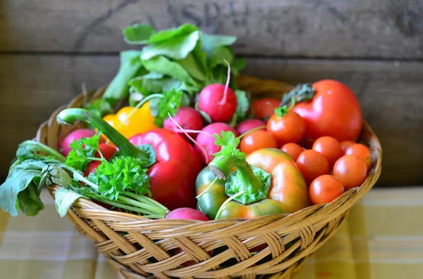 Tomates, rabanetes, pimentos, salsa e wickerwork handbasket — Fotografia de Stock