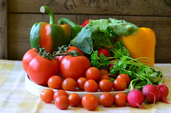 Tomatoes, radishes, peppers, parsley and wickerwork handbasket — Stock Photo, Image