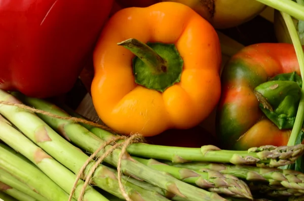 Peppers, asparagus, carrots and tomatoes in wooden box — Stock Photo, Image