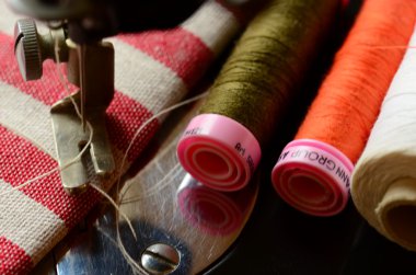 Beyaz iplik ve çizgili kumaş ile bağbozumu dikiş makinesi