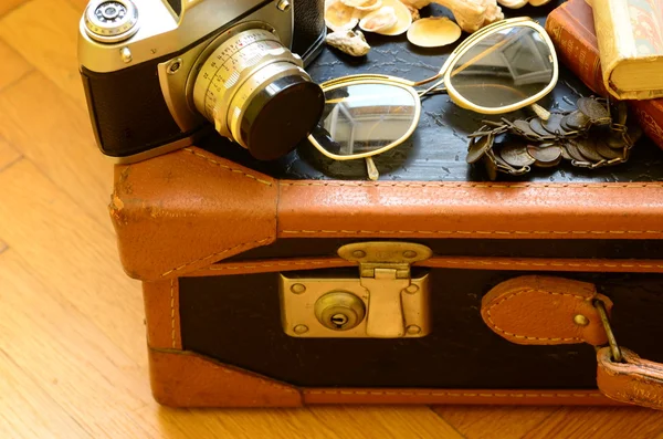 Rocznika walizki, kamera, okulary przeciwsłoneczne, muszle, bransoletka i stos książek. Vintage Podróże. — Zdjęcie stockowe