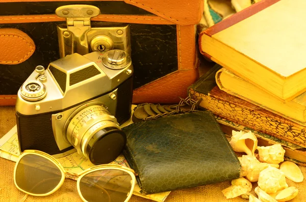 Mala vintage, câmera, óculos de sol, mapas, carteira e uma pilha de livros. Viagem vintage . — Fotografia de Stock