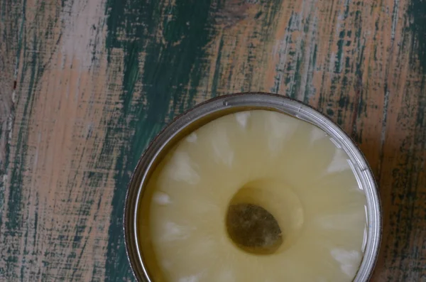 Ananas ahşap yeşil zemin üzerine teneke içinde.