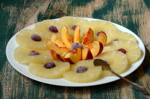 Нарежьте ананас нектарином и замороженными вишнями . — стоковое фото