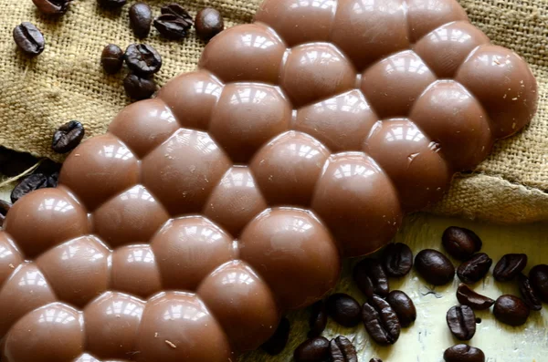 Кофейные зерна с шоколадной глазурью и темный шоколад на деревянном фоне . — стоковое фото