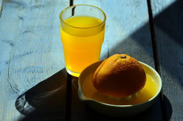 Sztuki martwa natura z soku pomarańczowego i porcelany Sokowirówka na drewnianym stole — Zdjęcie stockowe