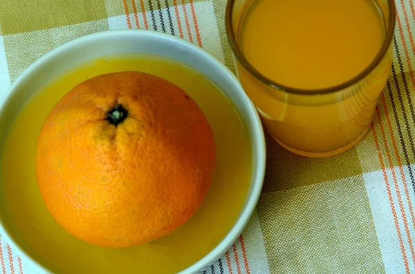 Retreat with orange juice and porcelain juicer on dish towel. — Stock Photo, Image