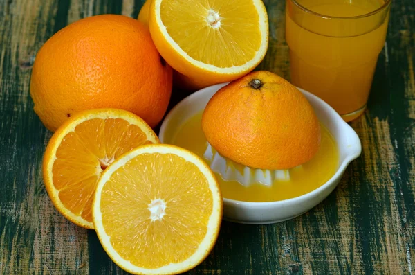 Bodegón de bellas artes con zumo de naranja y exprimidor de porcelana sobre mesa de madera . — Foto de Stock