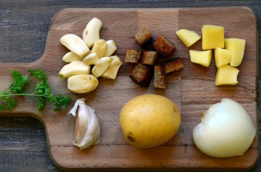 Doğrama kurulu üzerinde sarımsak çorbası için malzemeler.