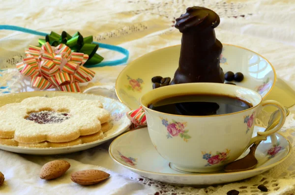 Deserturi cu ceașcă de cafea, boabe de cafea și migdale pe fața de masă albă . — Fotografie, imagine de stoc