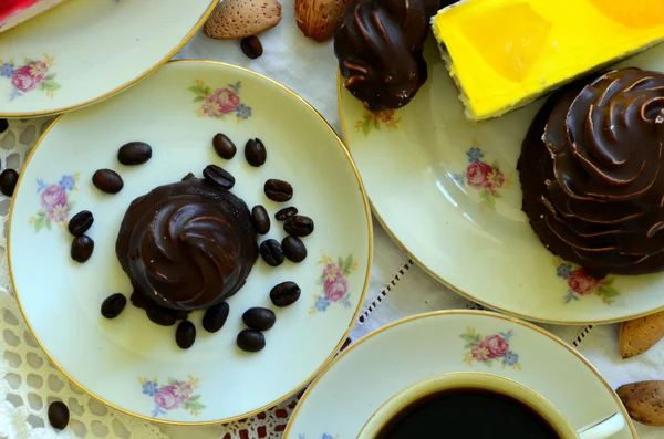 Desserter med kopp kaffe, kaffebönor och mandlar på vita duken. — Stockfoto