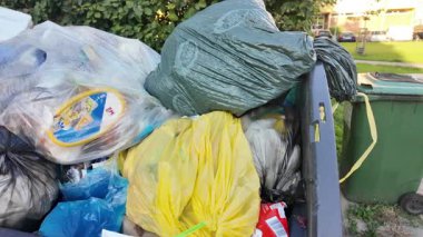 Çöp konteynırlarının içine bir göz atın. Atık dolu açık bir konteynır. Atık yönetimi ve çevresel etki kavramı.