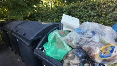 Çöp konteynırlarının içine bir göz atın. Atık dolu açık bir konteynır. Atık yönetimi ve çevresel etki kavramı.