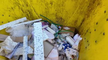 Çöp konteynırlarının içine bir göz atın. Atık dolu açık bir konteynır. Atık yönetimi ve çevresel etki kavramı.