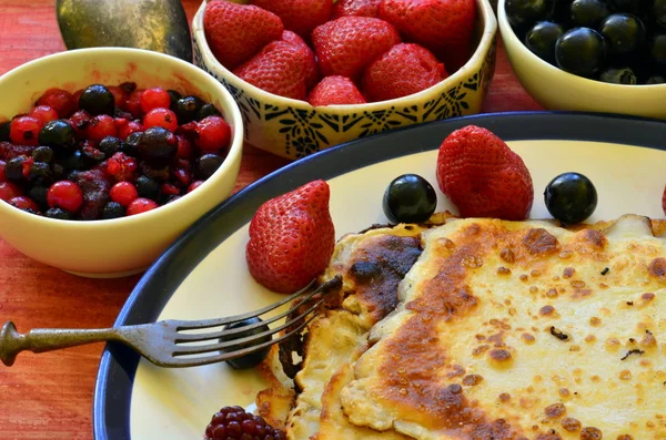 Crepes gostosos com morangos e huckleberries no fundo de madeira . — Fotografia de Stock