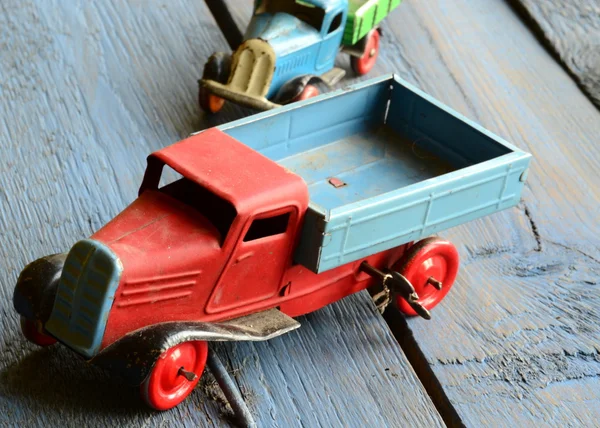 Set of vintage toys - trucks (lorries) toys on blue wooden background — Stock Photo, Image