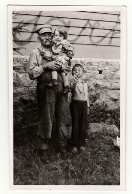 The small children with their grandfather. Vintage photo was taken in Hodonin (the Czech Republic). Early forties