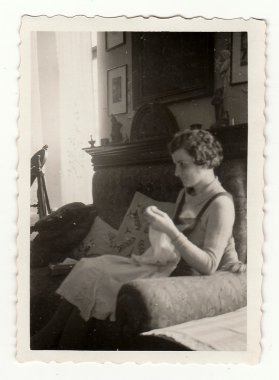 Woman is making embroidery. Vintage photo. The forties