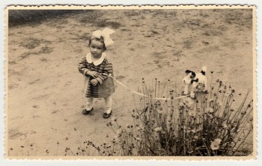 A small girl with toy dog. Vintage photo was taken in Hodonin (the Czech Republic). Early forties