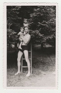 The small children with their uncle. Summer vintage photo was taken in Hodonin (the Czech Republic). Early forties