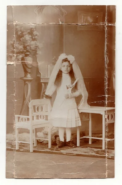 A young girl is doing her first holy communion. Vintage photo. The thirties. — Stock Fotó