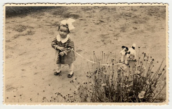 A small girl with toy dog. Vintage photo was taken in Hodonin (the Czech Republic). Early forties — Stock Fotó