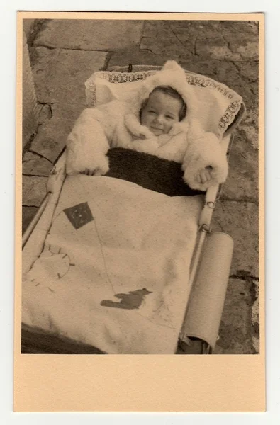 A baby girl in a pram (baby carriage) . Vintage photo was taken in Hodonin (the Czech Republic). Early forties — 图库照片