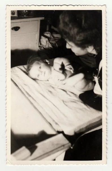 A small baby girl with her aunt. Vintage photo was taken in Hodonin (the Czech Republic). Early forties — стокове фото