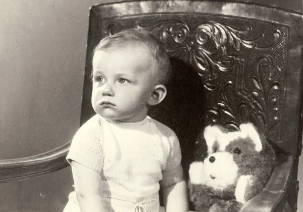 Foto retro de un niño pequeño con oso de peluche. La foto del retrato fue tomada en un estudio fotográfico. Principios de los setenta — Foto de Stock
