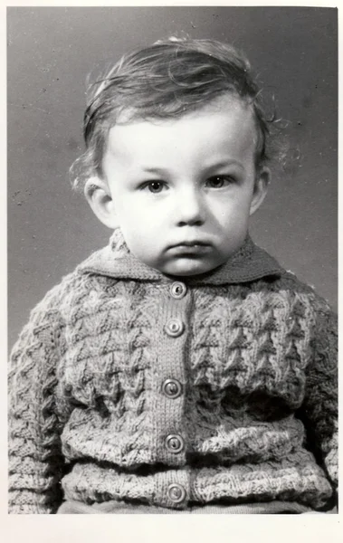 Uma foto retrô de menino pequeno. A foto do retrato foi tirada no estúdio de fotografia. No início dos anos setenta. Foto com tonalidade escura — Fotografia de Stock