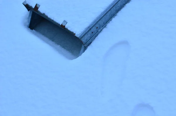 Telhado coberto de neve e faixas na neve e um velho dormer . — Fotografia de Stock