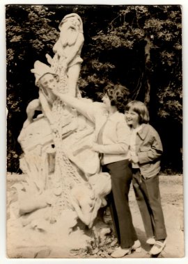 Vintage photo shows mother and daughter with a funny sculpture, circa 1970s.
