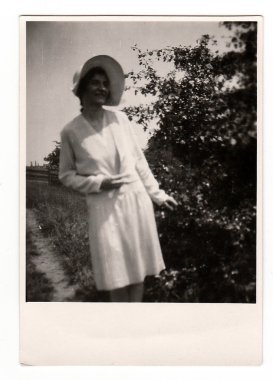 A vintage photo shows a young woman during a walk in nature, circa 1930s.