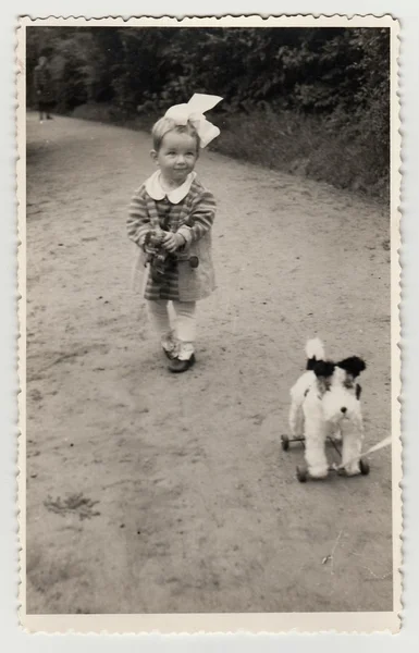 Uma menina pequena com brinquedo de cachorro, por volta de 1942 . — Fotografia de Stock