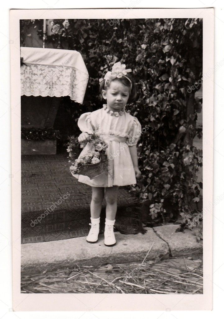 Vintage photo shows a small girl during religious (catholic) celebration, circa 1943.