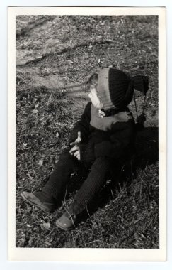 Vintage Fotoğraf çimenlerin üzerinde küçük bir çocuk oturur gösterir