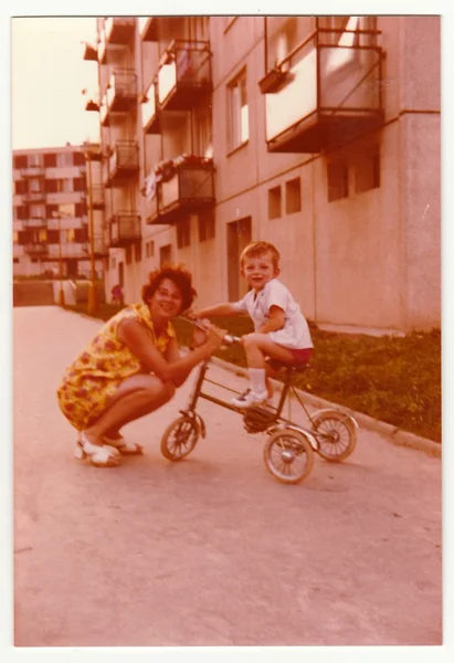 Vintage photo shows mother with her son on tricycle, circa 1974. — Stock Photo, Image