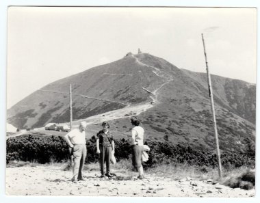 Vintage photo shows people on vacation, circa 1960s.