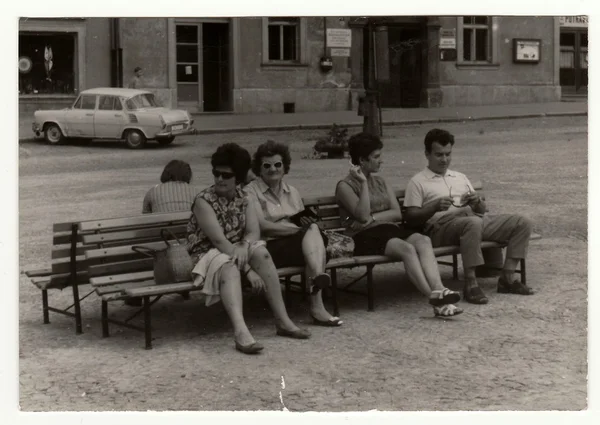 Vintage photo shows people sit on a bench, circa 1950s. — Stock fotografie