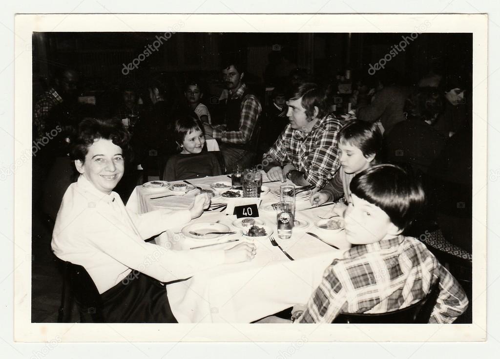 Vintage photo shows a group of people in the restaurant.