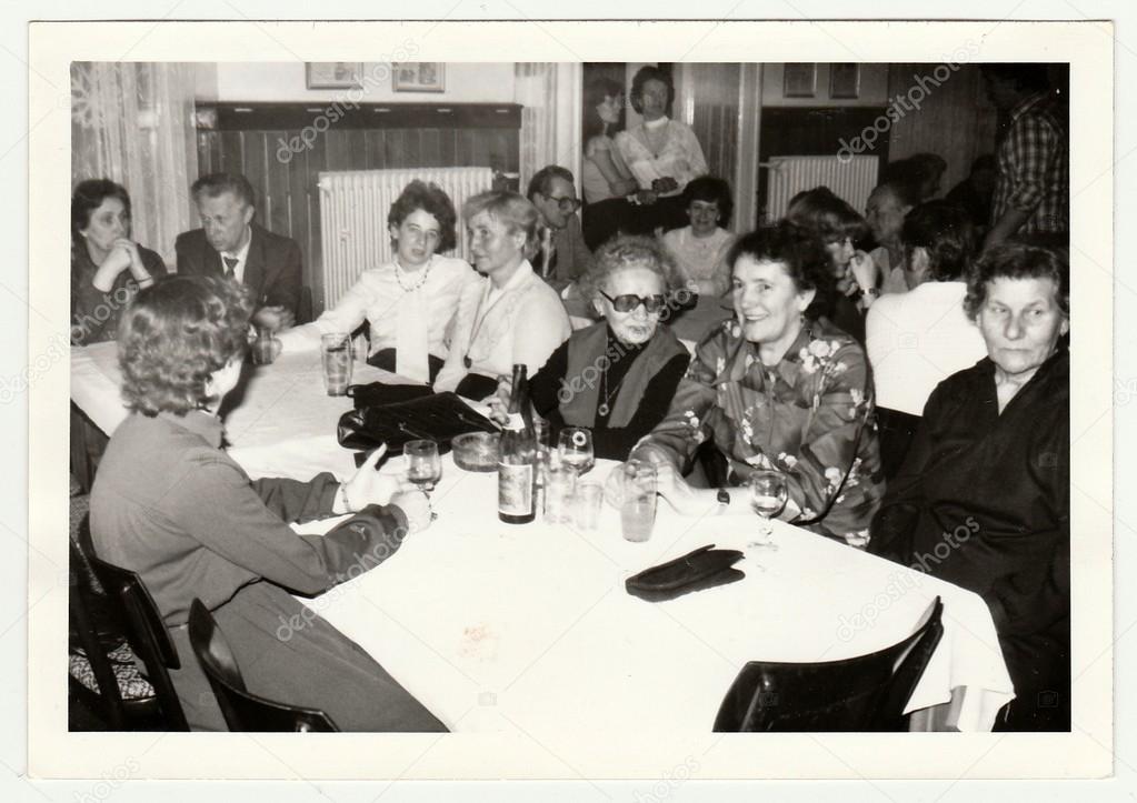 Vintage photo shows a group of people in the restaurant.