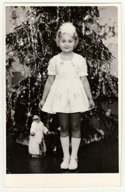 Vintage Fotoğraf Noel ağacı önünde küçük bir kız (yaklaşık 7 yıl eski) gösterir.