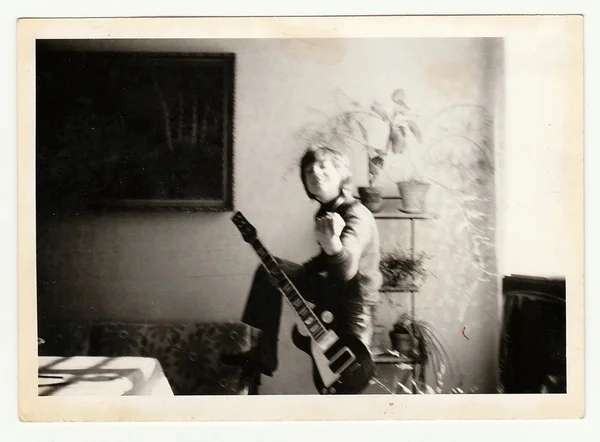 老式照片显示在吉他扮演了一个小男孩。照片有反射. — 图库照片