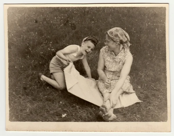 Vintage photo shows a mother with son have a rest on meadow — Stock Photo, Image