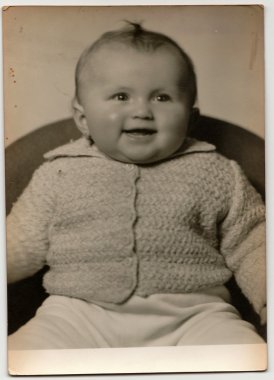 Vintage portre yeni yürümeye başlayan kız koltukta oturur gösterir. Siyah ve beyaz antika fotoğraf.