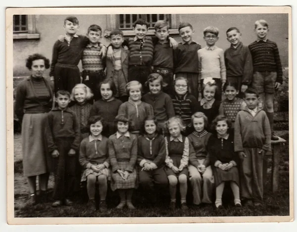 A vintage photo shows schoolmates with female teacher. — Stock Photo, Image