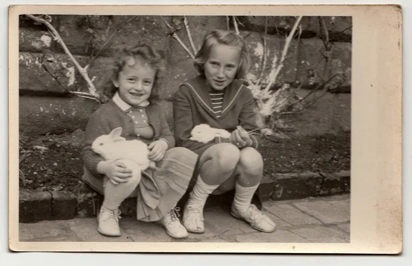 Foto vintage muestra niñas y conejos durante la Pascua . —  Fotos de Stock