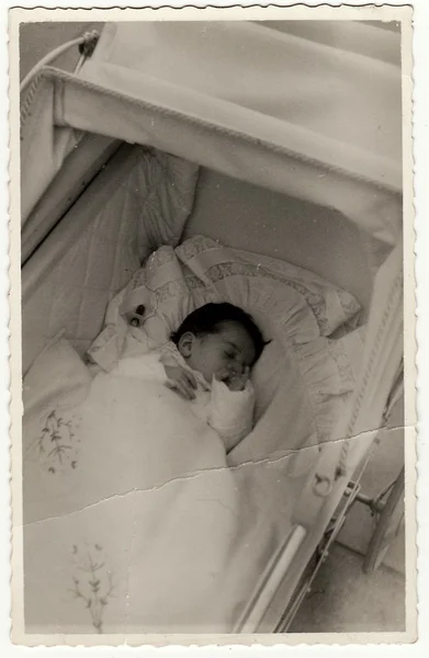 Uma foto vintage mostra uma pequena menina em um carrinho (carrinho de bebê ). — Fotografia de Stock