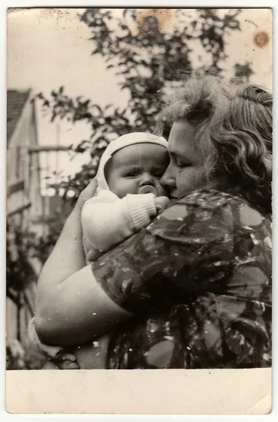 Vintage foto mostra jovem mulher berços bebê . — Fotografia de Stock